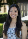 Person with long dark hair smiling outdoors at UC Berkeley